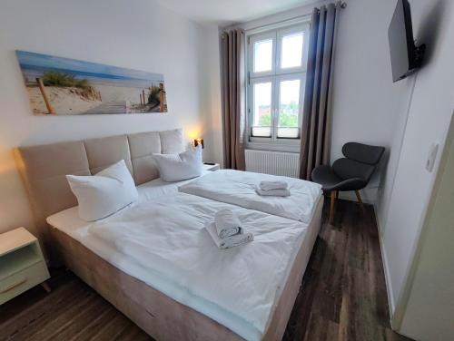 科瑟罗Villa Boberg Apartments的一间卧室配有一张带白色床单的床和一扇窗户。