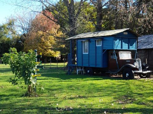 圣安东尼奥德阿雷科Los furgones de Areco的田野里一辆旧货车上的蓝色房子