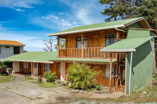 蒙泰韦尔德哥斯达黎加Cowboy Hostel - Habitaciones con Baño Privado的绿色屋顶的木屋