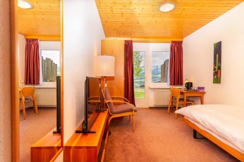 HembergHotel Swiss Views的一间卧室配有一张床,并在一间客房内配有电视。
