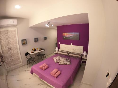 科孚镇MEMORIA的一间卧室配有一张紫色的床和一张桌子