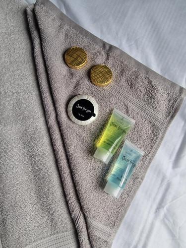 大雅茅斯SEA VIEW STAY 17 Princes Road的床上的灰色毛衣,带扣子和钱