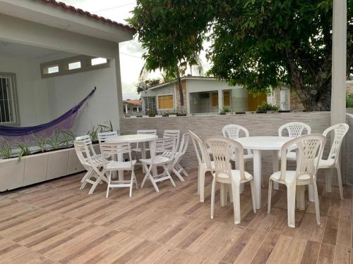 伊塔马拉卡casa de 4 quartos perto do Forte Orange Itamaracá的露台配有白色的桌椅