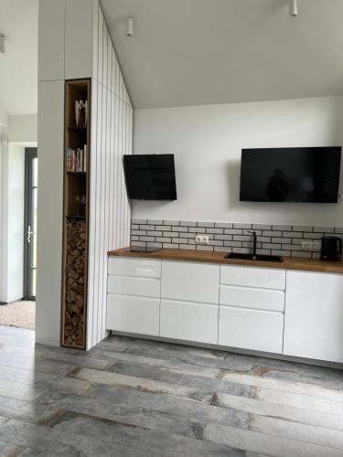 UtriaiUtriai Guest Place的厨房配有白色橱柜和壁挂式平面电视。