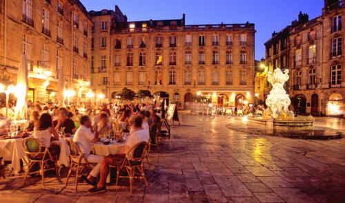 维勒纳夫多尔农Au Cocon d'Ornon - Top Location Bordeaux的一群人晚上坐在街上的桌子上