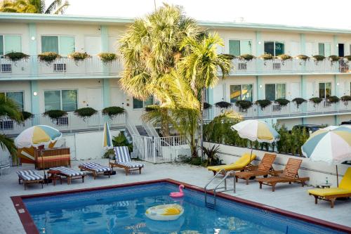 迈阿密Selina Gold Dust的酒店游泳池设有椅子和遮阳伞,酒店