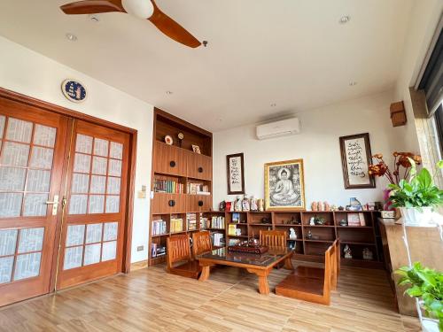 下龙湾Samatha Hotel Bai Chay, Ha Long的客厅配有桌椅和书架