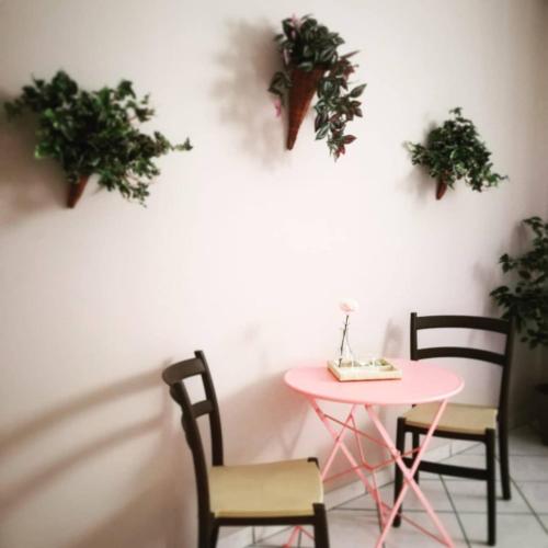 马斯卡卢恰I capricci dell'etna 4 di Puglisi的植物间里的粉红色桌子和椅子