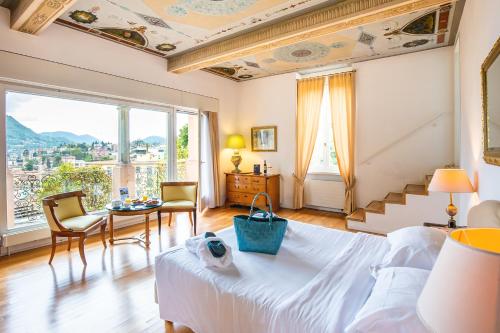 卢加诺Villa Sassa Hotel, Residence & Spa - Ticino Hotels Group的一间卧室配有一张床和一张桌子及椅子