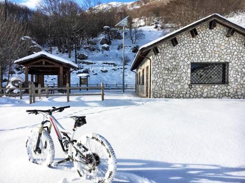 San Biagio SaracinescoLe Tre Dimore - Rifugio Aceroni的停在大楼前雪地里的自行车