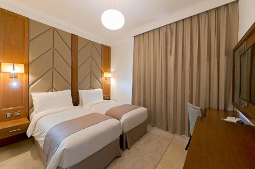 富查伊拉TIME Moonstone Hotel Apartments的酒店客房设有一张大床和一张桌子。