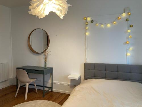 蒙贝利亚尔Appartement avec place de parking et box vélos的一间卧室配有一张床、一张桌子和一面镜子