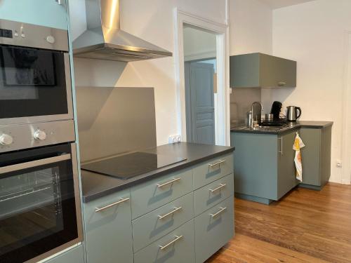 蒙贝利亚尔Appartement avec place de parking et box vélos的厨房配有灰色橱柜和炉灶烤箱