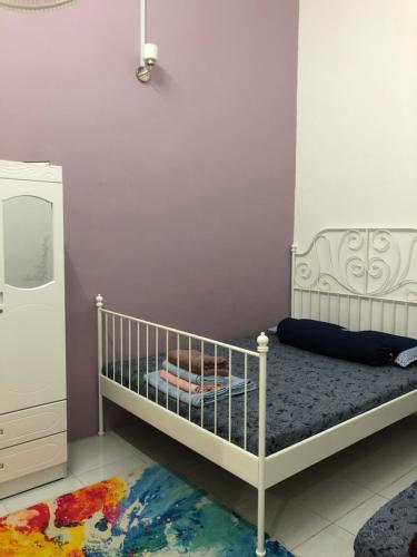 而连突Ina Homestay Jerantut的儿童卧室配有婴儿床和镜子