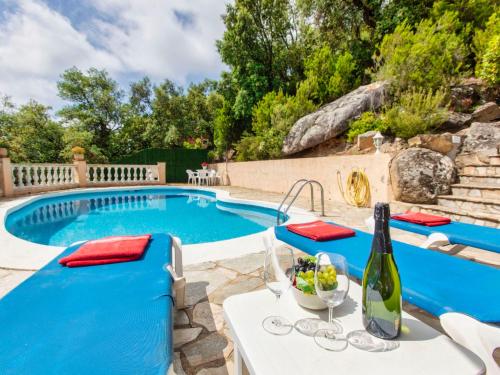 卡隆赫Holiday Home Bella Vista by Interhome的一个带桌椅的游泳池和一瓶葡萄酒