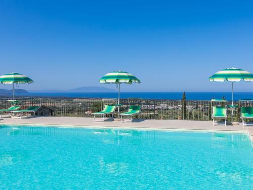 圣温琴佐Holiday Home Il Corbezzolo-2 by Interhome的一个带绿色椅子和遮阳伞的游泳池
