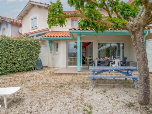 米尼赞海滩Holiday Home Le Hameau des Pêcheurs 5-1 by Interhome的房屋前方的天井配有蓝色野餐桌