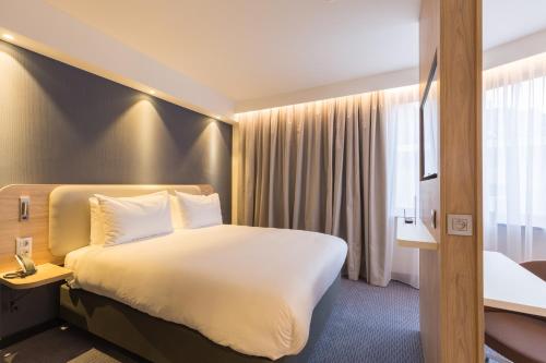 布鲁塞尔Holiday Inn Express Brussels-Grand-Place, an IHG Hotel的一间设有大床和窗户的酒店客房