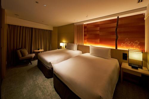 东京东京雅叙园酒店的酒店客房,配有两张床和椅子