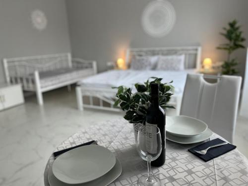 布达佩斯Camille Apartmanhouse的一张桌子,上面放有盘子,一瓶葡萄酒和一杯