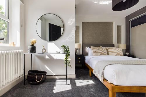 伦敦The Battersea Flat - Exquisite 2BDR Flat with Terrace的一间卧室配有一张床和镜子
