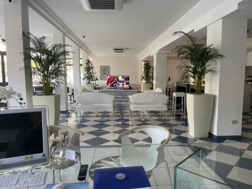 利尼亚诺萨比亚多罗雅典娜酒店 的大堂设有一张桌子、一台电脑和椅子