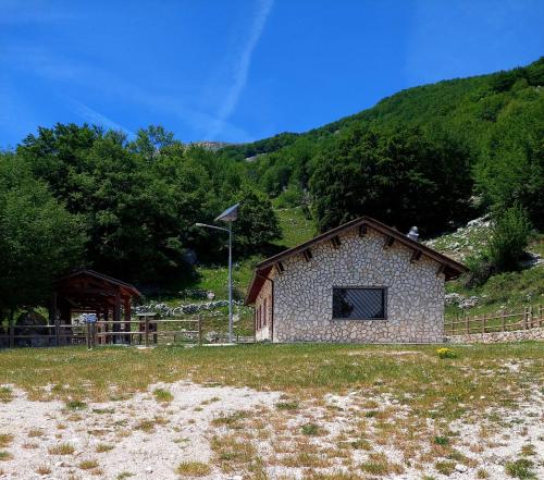 San Biagio SaracinescoLe Tre Dimore - Rifugio Aceroni的山地里的一座小石头建筑