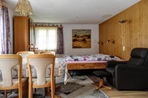 伦克Ferienwohnung Lenk的一间卧室配有一张带椅子和桌子的床