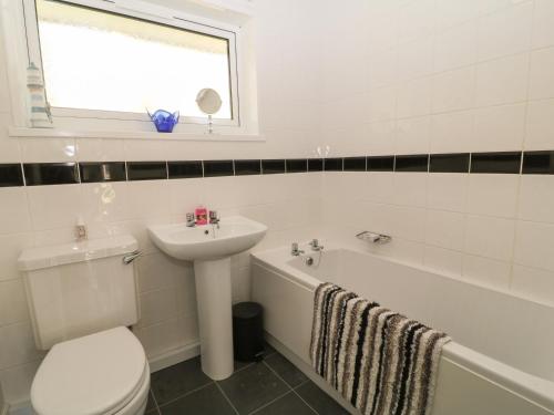 利斯卡德Ballasalla的浴室配有卫生间、盥洗盆和浴缸。