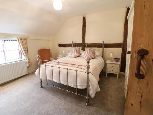 伊肯斯顿Hobson's Cottage 10 Main Street的一间卧室配有一张带白色床单的床和一扇窗户。