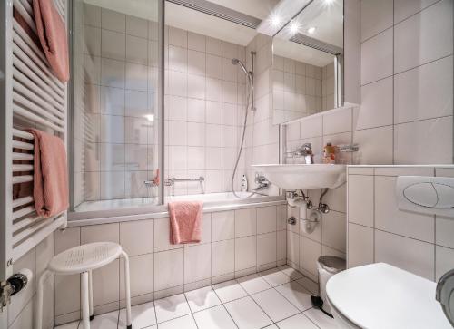 阿罗萨Bristol 41 Ferienwohnung im Herzen von Arosa的白色的浴室设有水槽和淋浴。