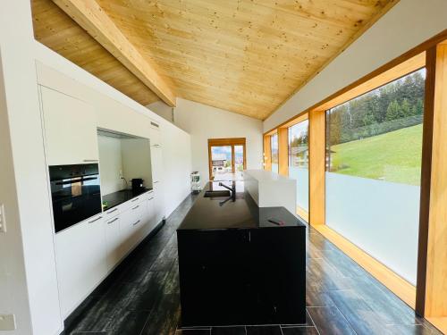 上萨克森3 bedroom condo in front of Obersaxen ski resort的厨房拥有白色的墙壁和木制天花板