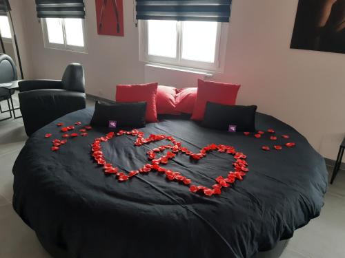 南希Ds Plaisir Love Room avec sauna, jacuzzi à Nancy的红玫瑰制成的心床