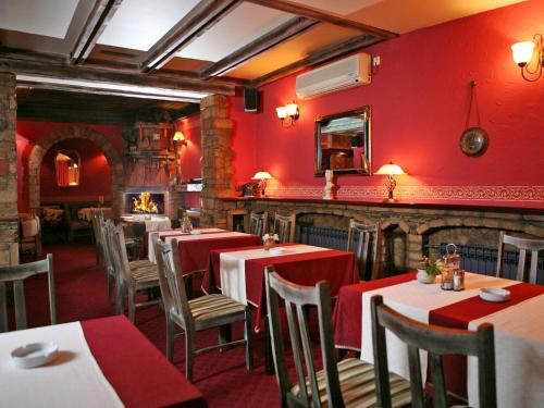 巴尼亚卢卡维多利亚别墅酒店的餐厅拥有红色的墙壁和桌椅
