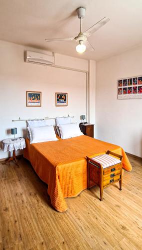 卡梅拉诺Fuori Porta Apartment的一间卧室配有一张带橙色毯子的大床