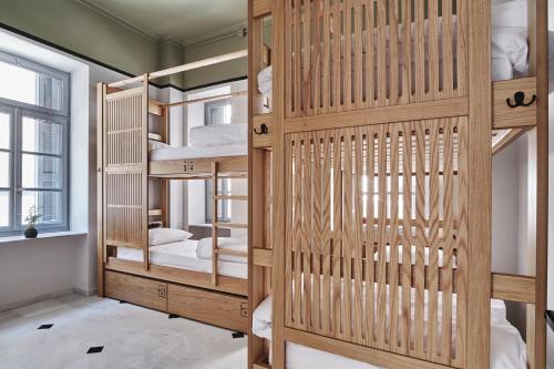 雅典When in Athens Hostel的客房设有木制双层床和窗户。