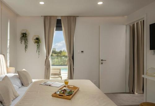 沃希Villa Coralis With Heated Pool的一间卧室配有一张床,上面放着一个食物托盘