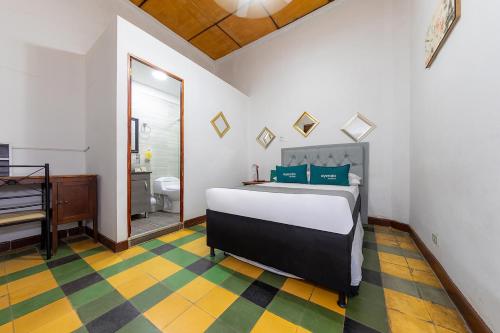 麦德林Ayenda Sarayu House的一间卧室配有一张床,浴室内配有钢琴