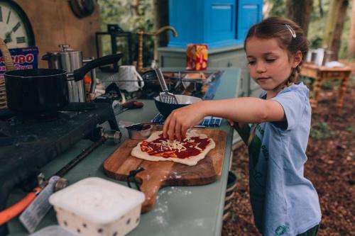 HallatonThe Sleepy Explorer的一个小女孩在切纸板上制作比萨饼
