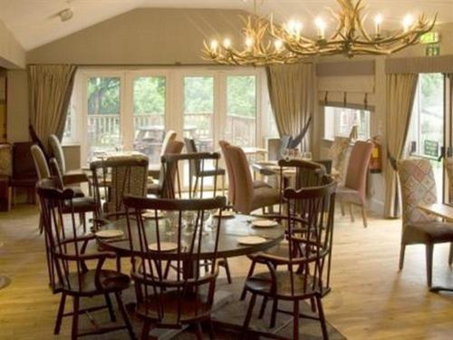 吉尔福德珀西阿姆斯酒店的一间带桌椅和吊灯的用餐室