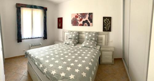 苏昂博Gerry&Lotti Apartment的卧室配有一张带灰色和白色棉被的床