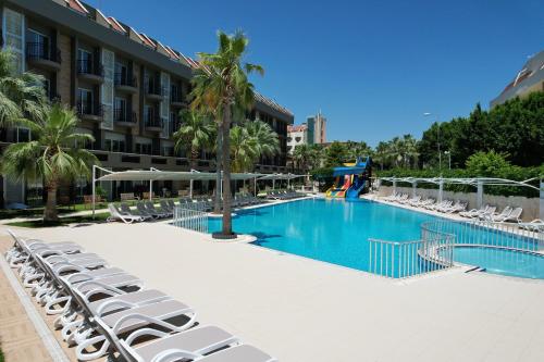 凯麦尔松树园海滩酒店的一个带躺椅的大型游泳池和一间酒店