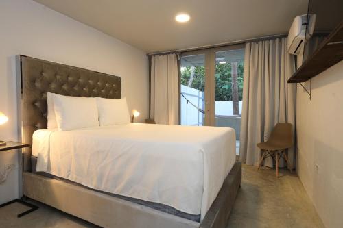 多拉多Viento Beach Lodge的一间带一张白色大床的卧室和一个阳台