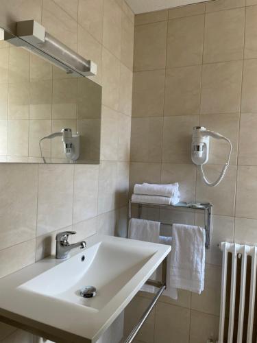 勒旺Hôtel La Vigneraie的浴室配有盥洗盆、镜子和毛巾