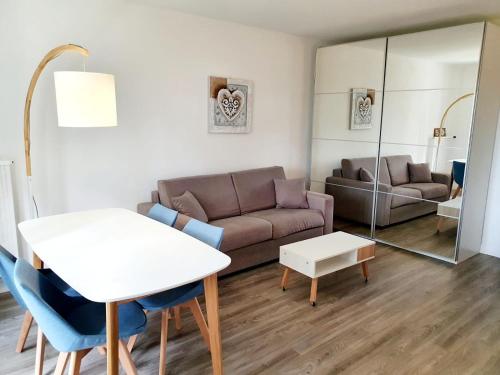 滨海伯内尔维尔Le bord de plage的客厅配有沙发和桌子