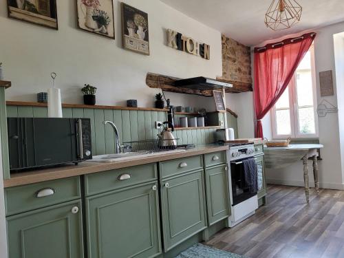阿尔纳克－蓬帕杜尔Gîte du Vieux Lavoir的厨房配有绿色橱柜和水槽