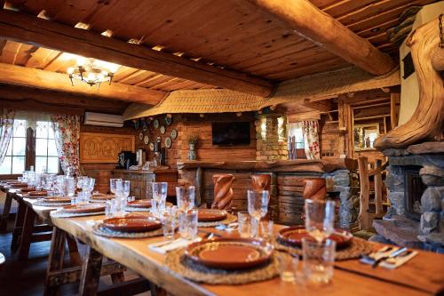 PuńskSiedlisko Sodyba的用餐室配有带玻璃杯的长桌