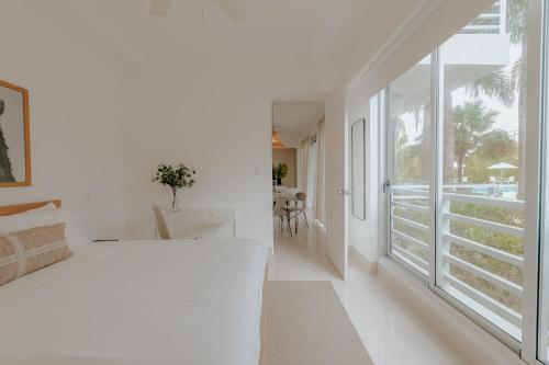 蓬塔卡纳Lumina at Palms Punta Cana Village的卧室设有白色的床和大窗户