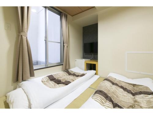 大阪Hotel Shin-Imamiya - Vacation STAY 36320v的带窗户的客房内的两张床