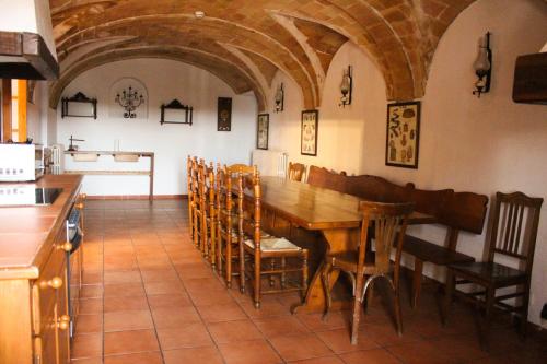 赫罗纳Mas Goy, casa rural con piscina的厨房以及带木桌和椅子的用餐室。